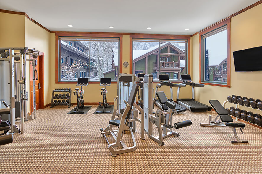 Fitness room with exercise equipment such as stationary bicycles and free weights. 