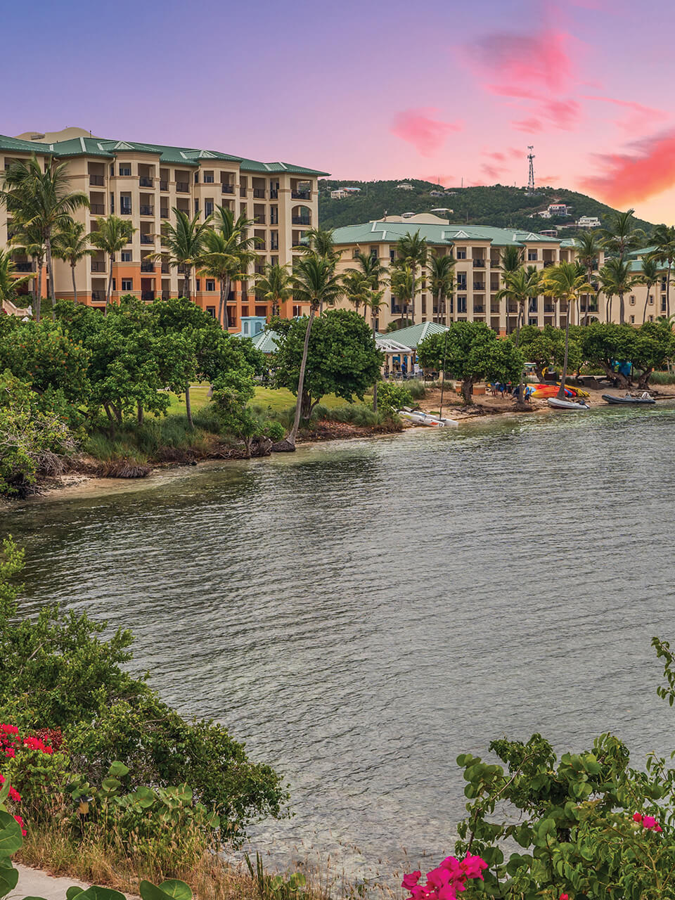 Ritz Carlton Club St. Thomas exterior resort with palm tree lined waters edge at sunset