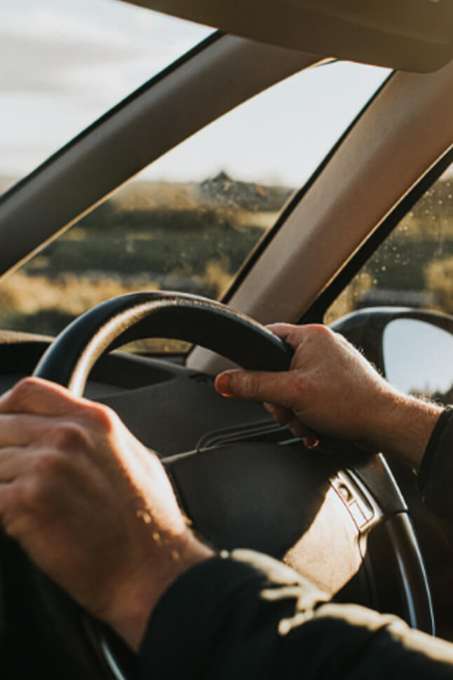 Person driving to explore with two hands on the wheel .