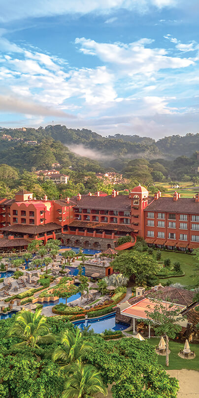 Red painted vacation resort nestled in mountains and greenery