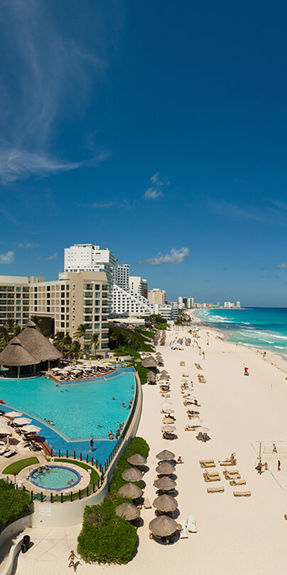 Beach resort with turquoise water and sandy beaches lined with lounge chairs and umbrellas