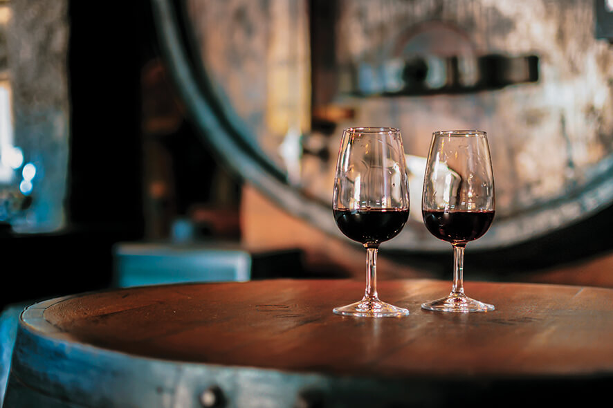 Wine glasses with red wine on a round rough hewn table