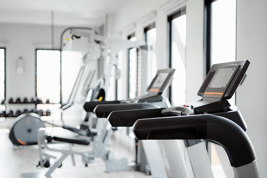 Fitness center featuring treadmills and other equipment in a white room.