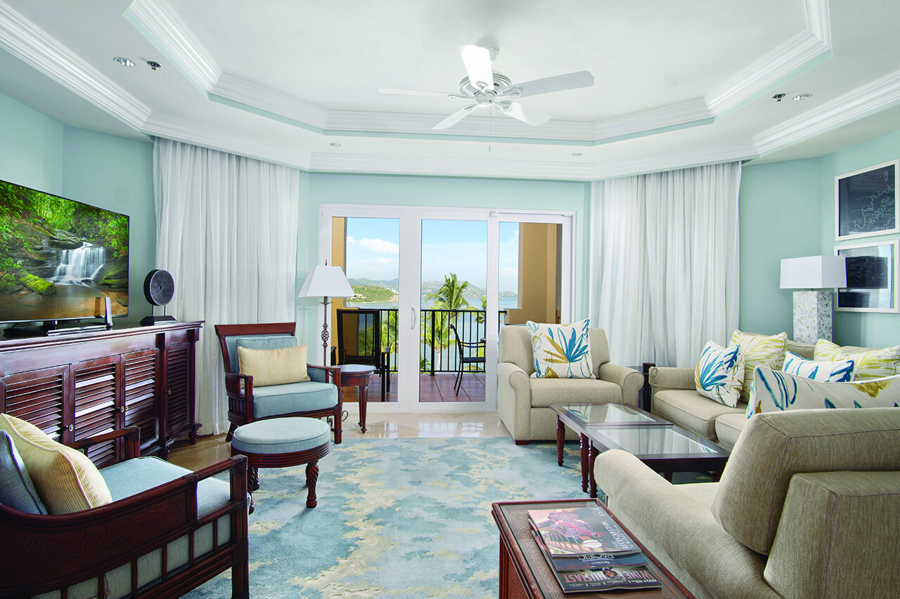 Living room with turquoise blue and white accents, water views, and wood furniture with blue and white fabrics