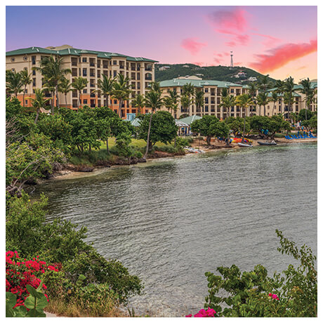 Sunset at a resort with water views and lush green foliage