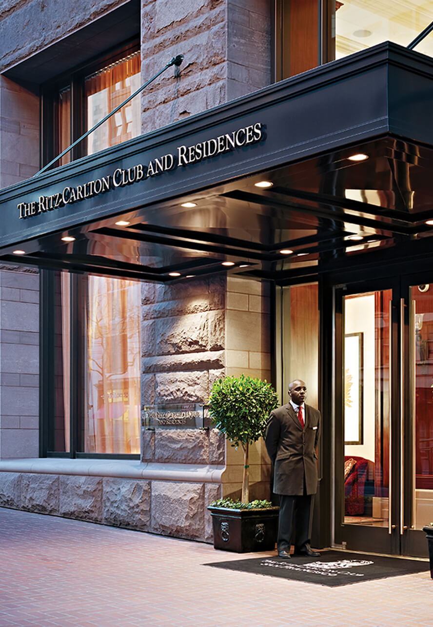 Doorman standing at the exterior entrance to the Ritz Carlton Club and Residences in San Francisco.